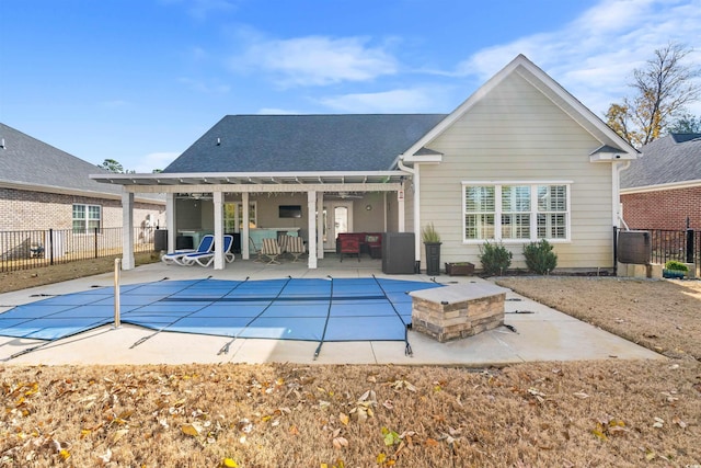 back of house with a patio area, an outdoor living space, and a covered pool