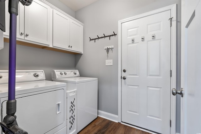 clothes washing area with cabinets, washer and clothes dryer, and dark hardwood / wood-style flooring