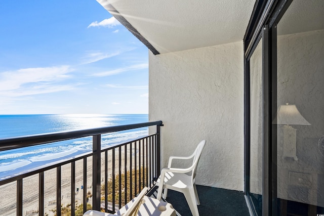 balcony with a water view and a beach view