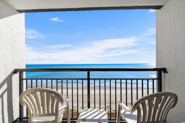 balcony with a beach view and a water view