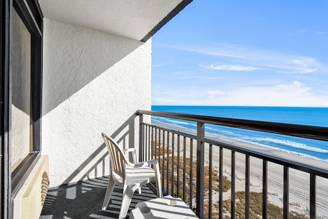 balcony featuring a beach view and a water view