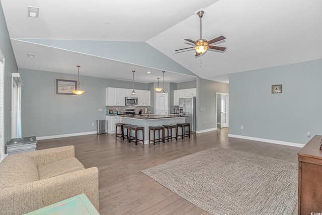 living room with ceiling fan, dark wood-type flooring, and vaulted ceiling