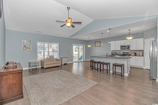 living room with light wood-type flooring, ceiling fan, and lofted ceiling