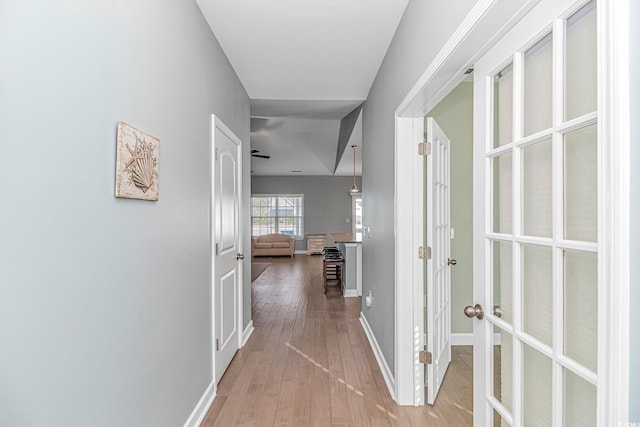 hallway with light hardwood / wood-style floors