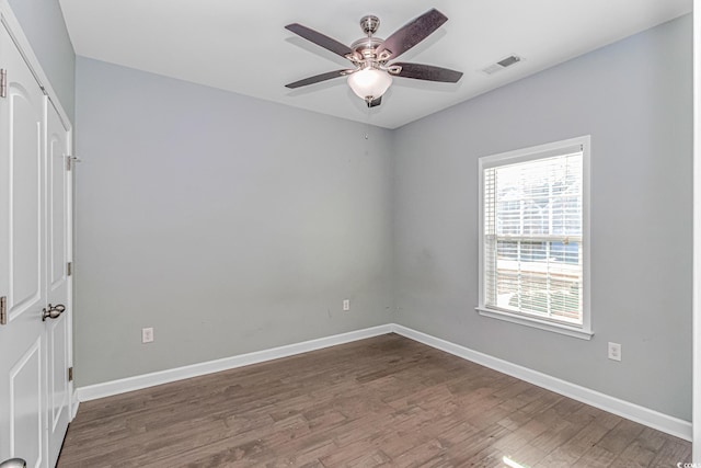 unfurnished room featuring ceiling fan and dark wood-type flooring