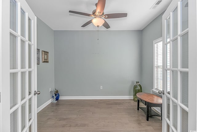 living area featuring french doors, light hardwood / wood-style flooring, and ceiling fan