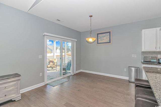 unfurnished dining area with wood-type flooring