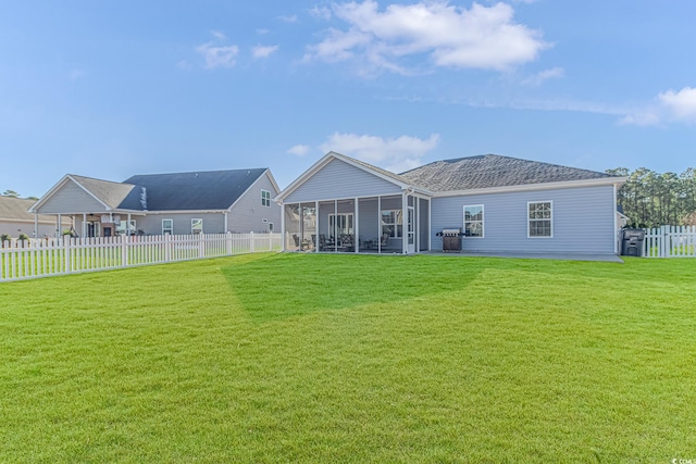 back of house featuring a lawn and a sunroom