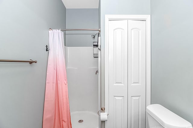 bathroom with a shower with curtain and toilet