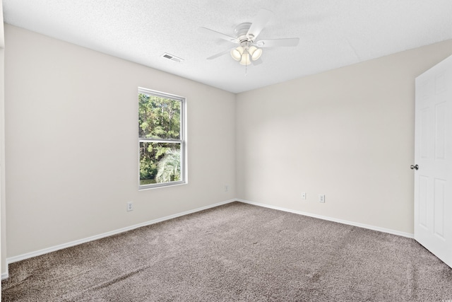 empty room with carpet flooring, ceiling fan, and a textured ceiling