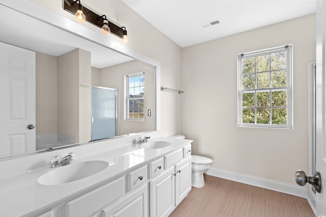 bathroom with hardwood / wood-style floors, vanity, an enclosed shower, and a healthy amount of sunlight