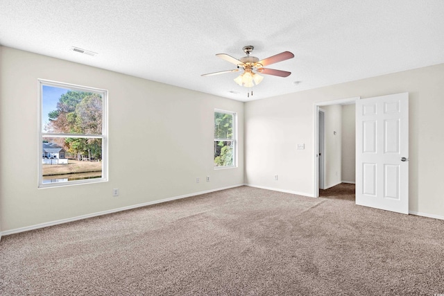 carpeted spare room with ceiling fan and a textured ceiling