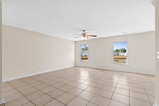 tiled spare room featuring a textured ceiling and ceiling fan