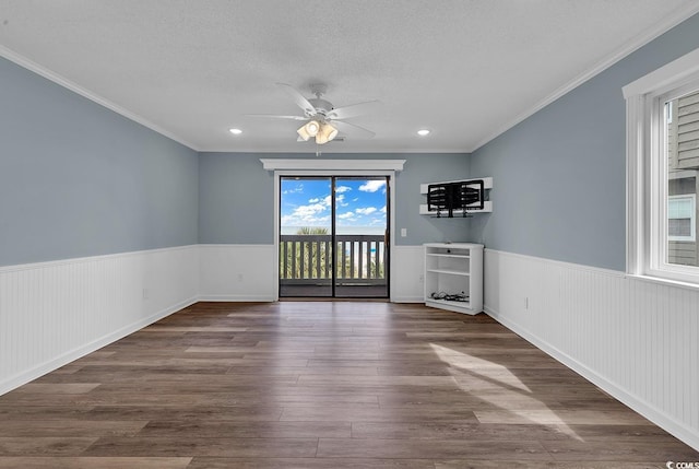 unfurnished room featuring a textured ceiling, crown molding, ceiling fan, and dark hardwood / wood-style floors