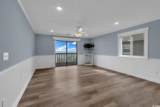 unfurnished living room with a textured ceiling, hardwood / wood-style flooring, ceiling fan, and ornamental molding