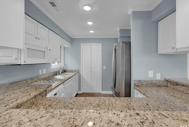 kitchen with light stone counters, sink, white cabinets, and white appliances