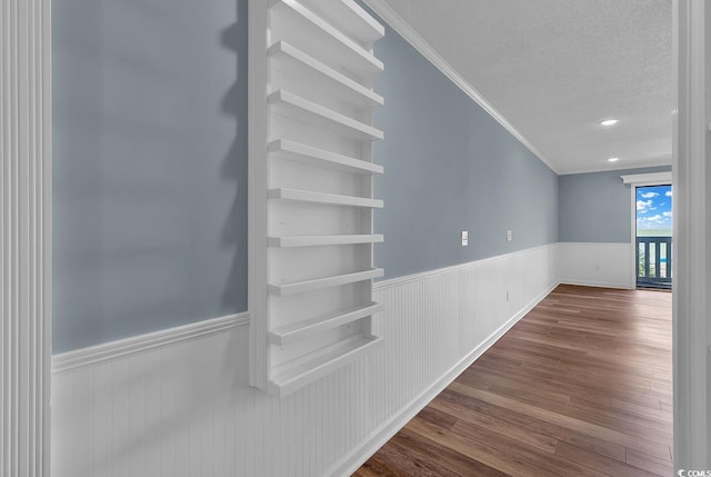 interior space featuring hardwood / wood-style floors, ornamental molding, and a textured ceiling