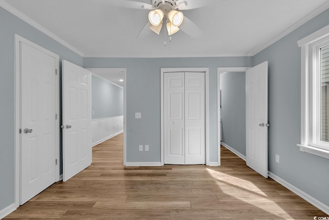 unfurnished bedroom with ceiling fan, ornamental molding, multiple windows, and light hardwood / wood-style flooring