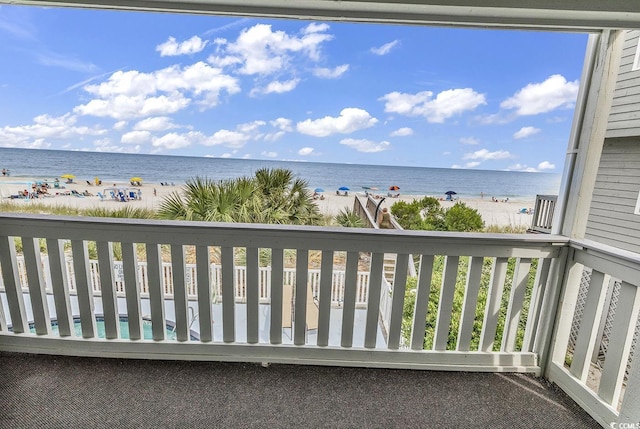 balcony featuring a view of the beach and a water view