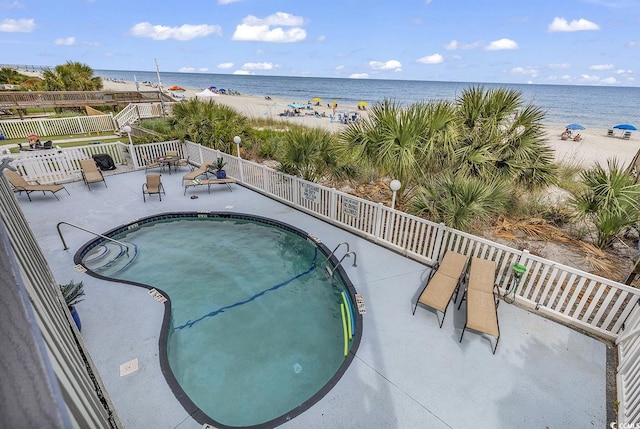 view of pool featuring a water view and a view of the beach