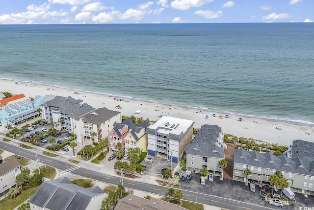 drone / aerial view featuring a water view and a beach view