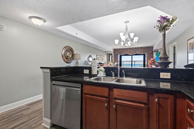 kitchen with sink, dark wood-type flooring, dishwasher, a textured ceiling, and a raised ceiling