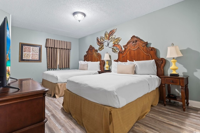 bedroom featuring hardwood / wood-style flooring and a textured ceiling