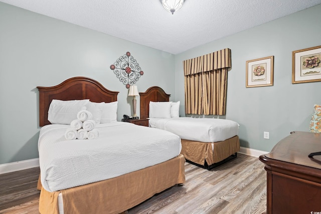 bedroom with hardwood / wood-style flooring and a textured ceiling