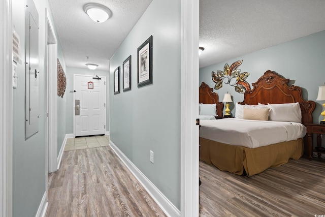 hallway featuring wood-type flooring and a textured ceiling