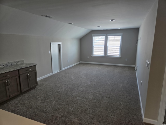 bonus room featuring lofted ceiling, carpet flooring, visible vents, and baseboards