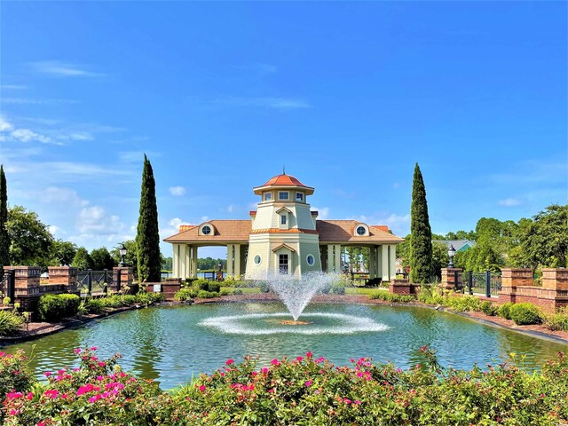 view of building exterior featuring a water view and fence