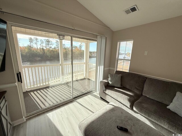 interior space featuring hardwood / wood-style flooring, vaulted ceiling, and a water view