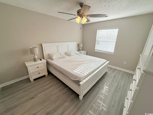 bedroom featuring a textured ceiling, ceiling fan, and light hardwood / wood-style floors