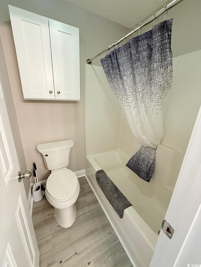 bathroom featuring wood-type flooring and toilet