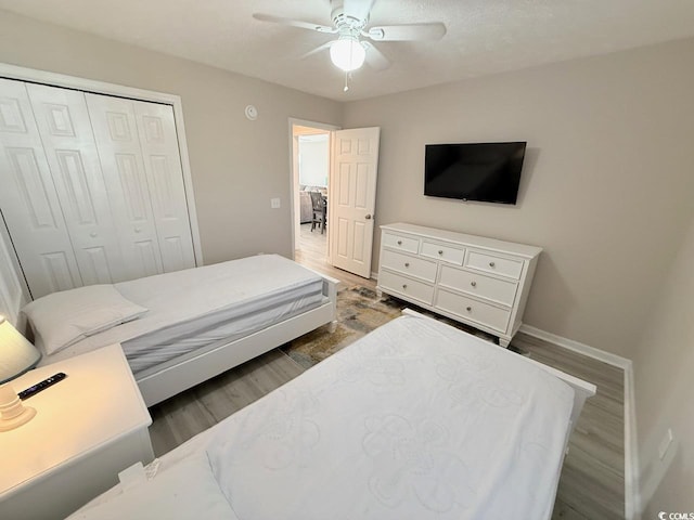 bedroom featuring hardwood / wood-style floors, ceiling fan, and a closet