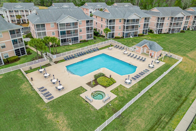 view of swimming pool featuring a community hot tub, a patio, and a lawn