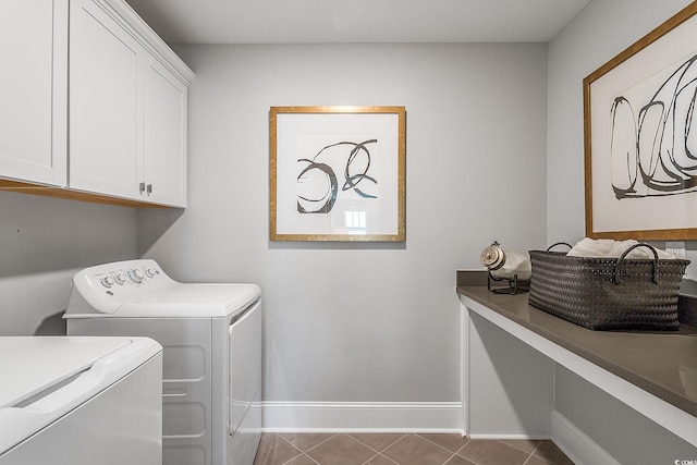 laundry room featuring washer and dryer, cabinets, and dark tile patterned floors