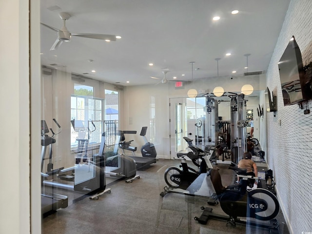 exercise room featuring ceiling fan and brick wall