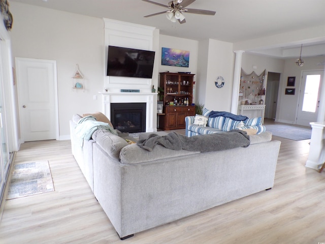 3070 Sutherland Dr, Little River, SC 29566 - living room featuring a ceiling fan, a glass covered fireplace, light wood-type flooring, and baseboards
