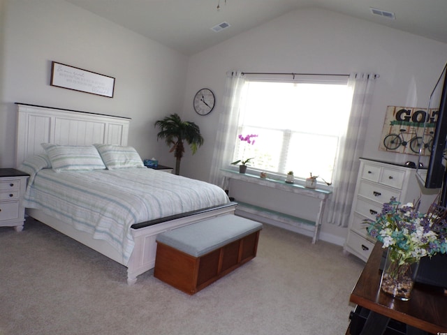 bedroom with light colored carpet, lofted ceiling, and visible vents