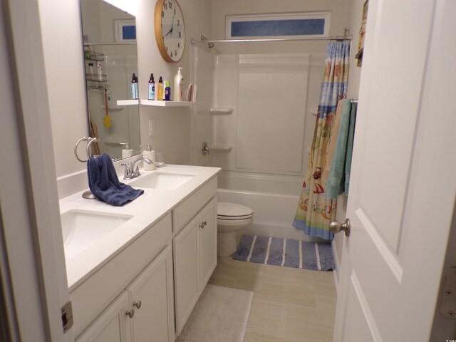 full bathroom with double vanity, toilet, a sink, and shower / bath combo