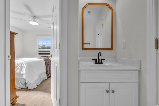 bathroom with hardwood / wood-style flooring, ceiling fan, and vanity