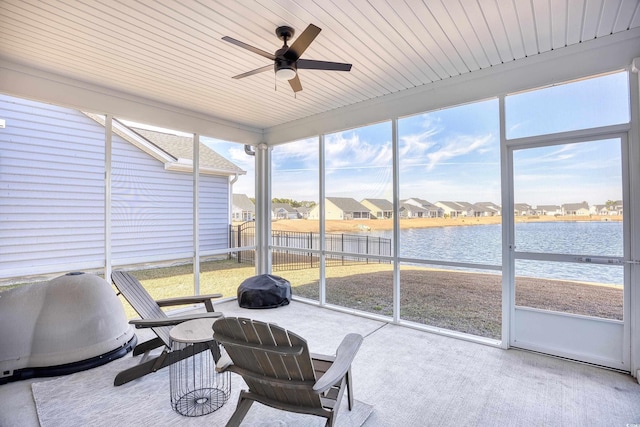 sunroom featuring ceiling fan, a healthy amount of sunlight, a water view, and wood ceiling