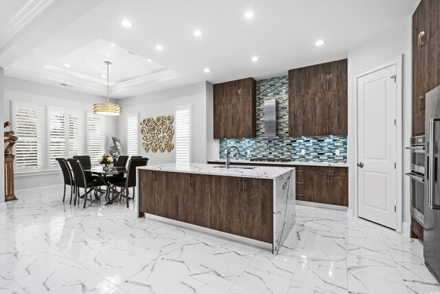 6105 Bolsena Pl, Myrtle Beach, SC 29577 - kitchen featuring recessed lighting, decorative backsplash, dark brown cabinetry, modern cabinets, and a kitchen island with sink