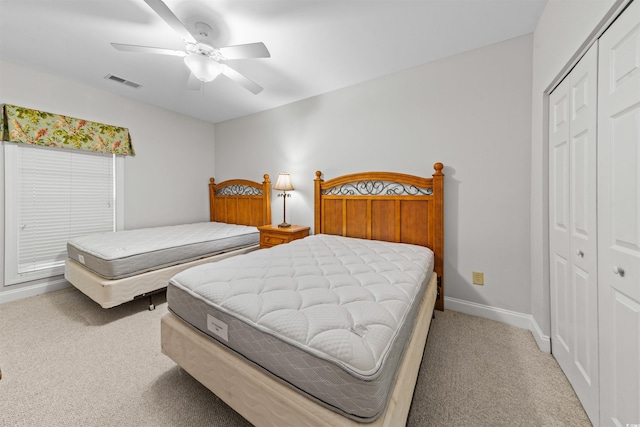 carpeted bedroom featuring a closet and ceiling fan