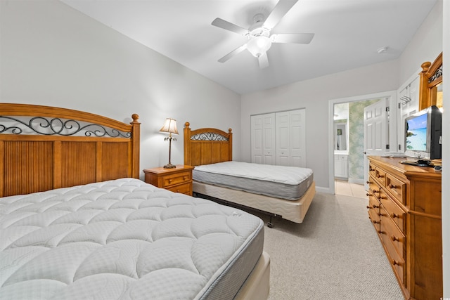 bedroom with connected bathroom, ceiling fan, a closet, and light carpet