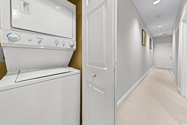 laundry room with stacked washer / dryer and light carpet