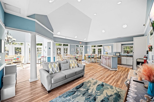 living room featuring an inviting chandelier, french doors, high vaulted ceiling, and light hardwood / wood-style flooring