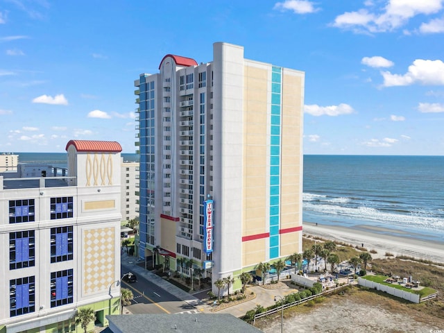 view of property with a water view and a beach view