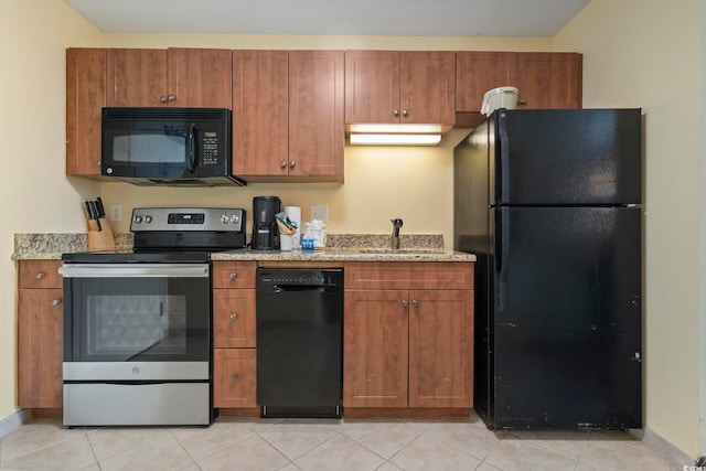 kitchen featuring light stone countertops, light tile patterned floors, sink, and black appliances